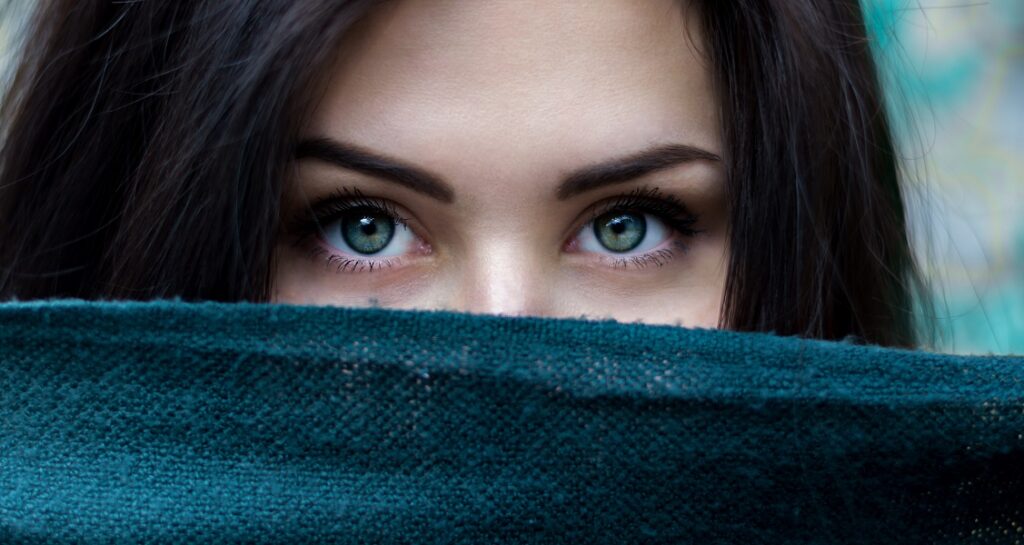 Woman dark hair green eyes scarf Photo by Alexandru Zdrobău on Unsplash