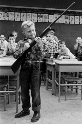 Elementary school boy with rifle in class 1956 Caveman Circus
