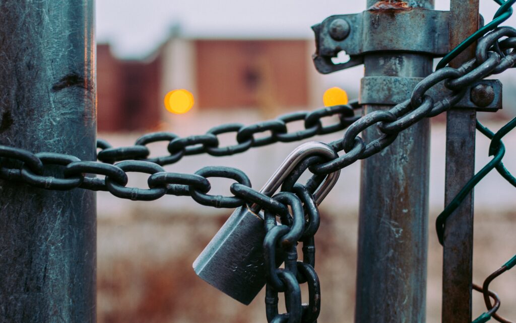 Lock chain loged gate closed Photo by Jose Fontano on Unsplash